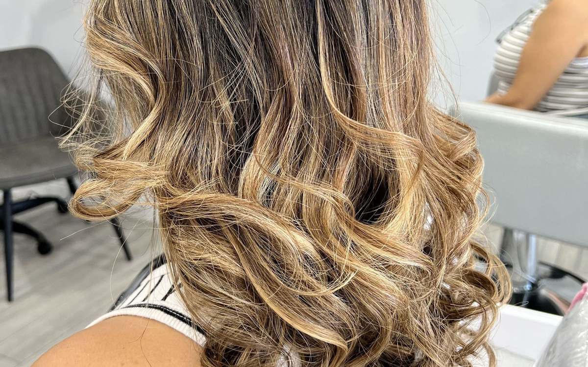 Client with finished balayage waves in honey-blonde tones at TRUE Beauty Hair Lounge